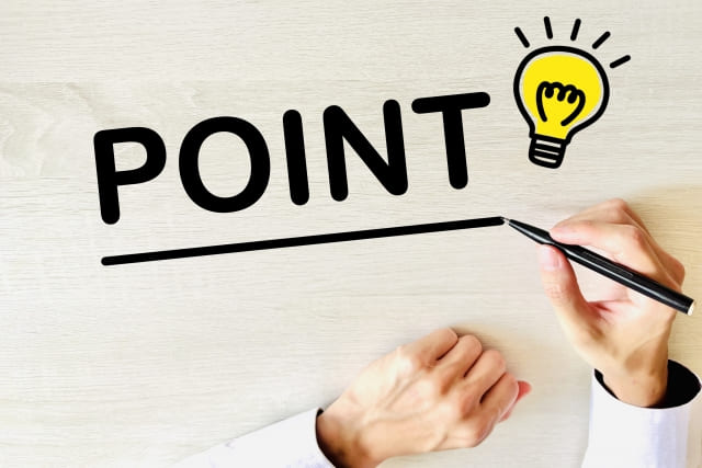 机にポイントの文字を書く手の画像