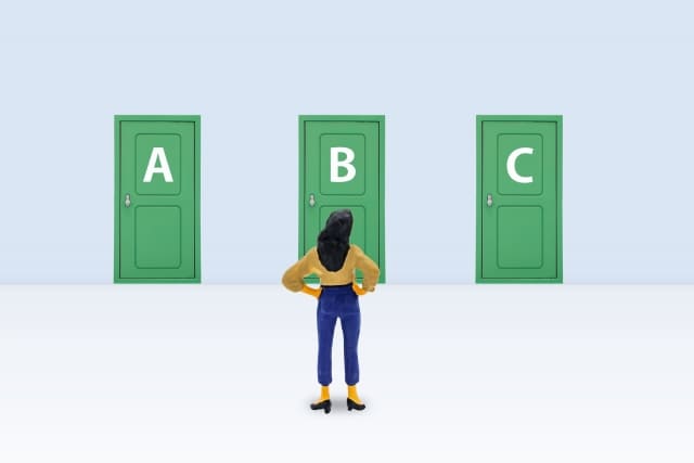 A、B,、Cとかかれた3つの扉の前で選択に悩むイメージ画像